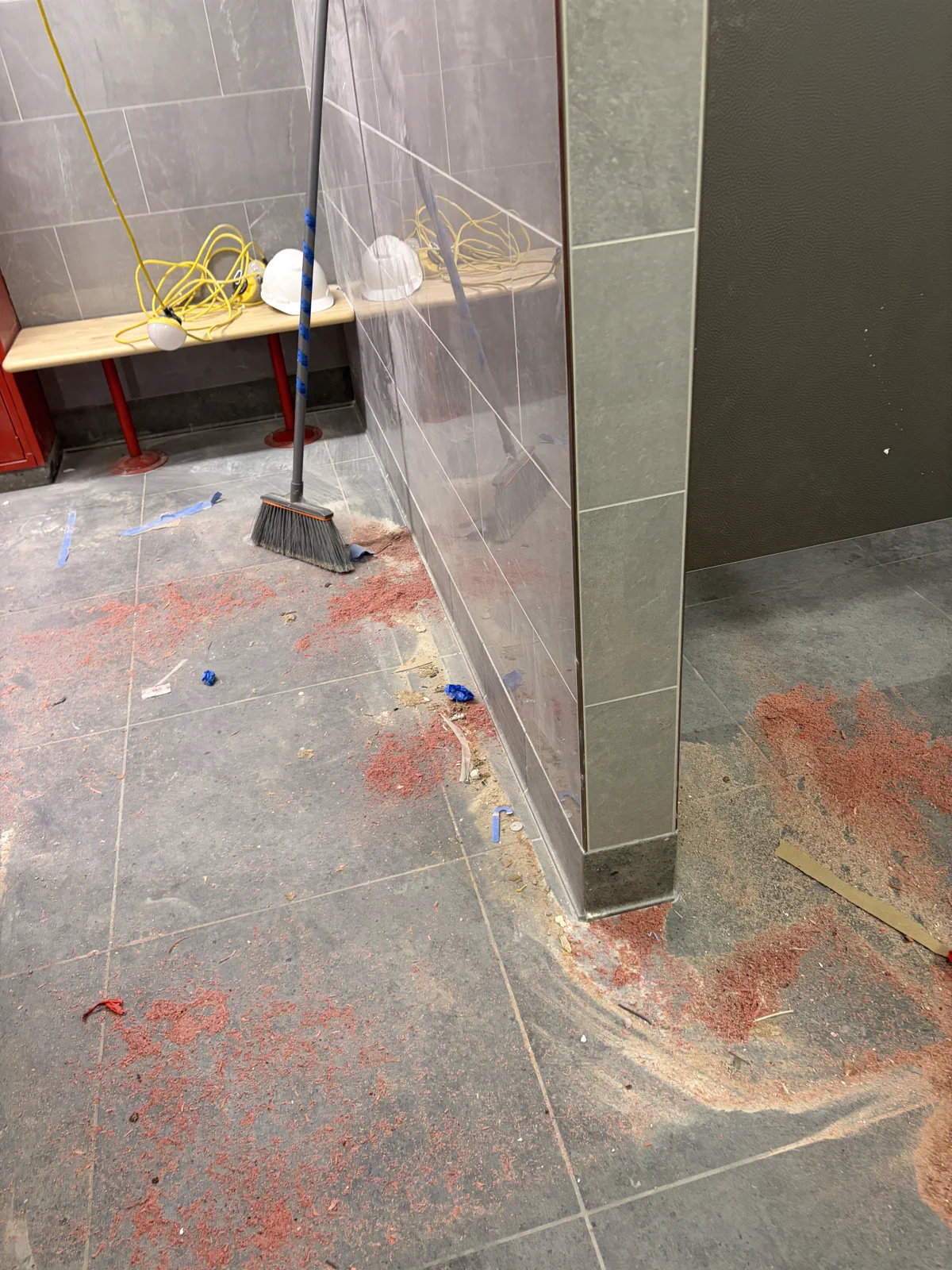 Locker room during construction cleanup with debris on the floor